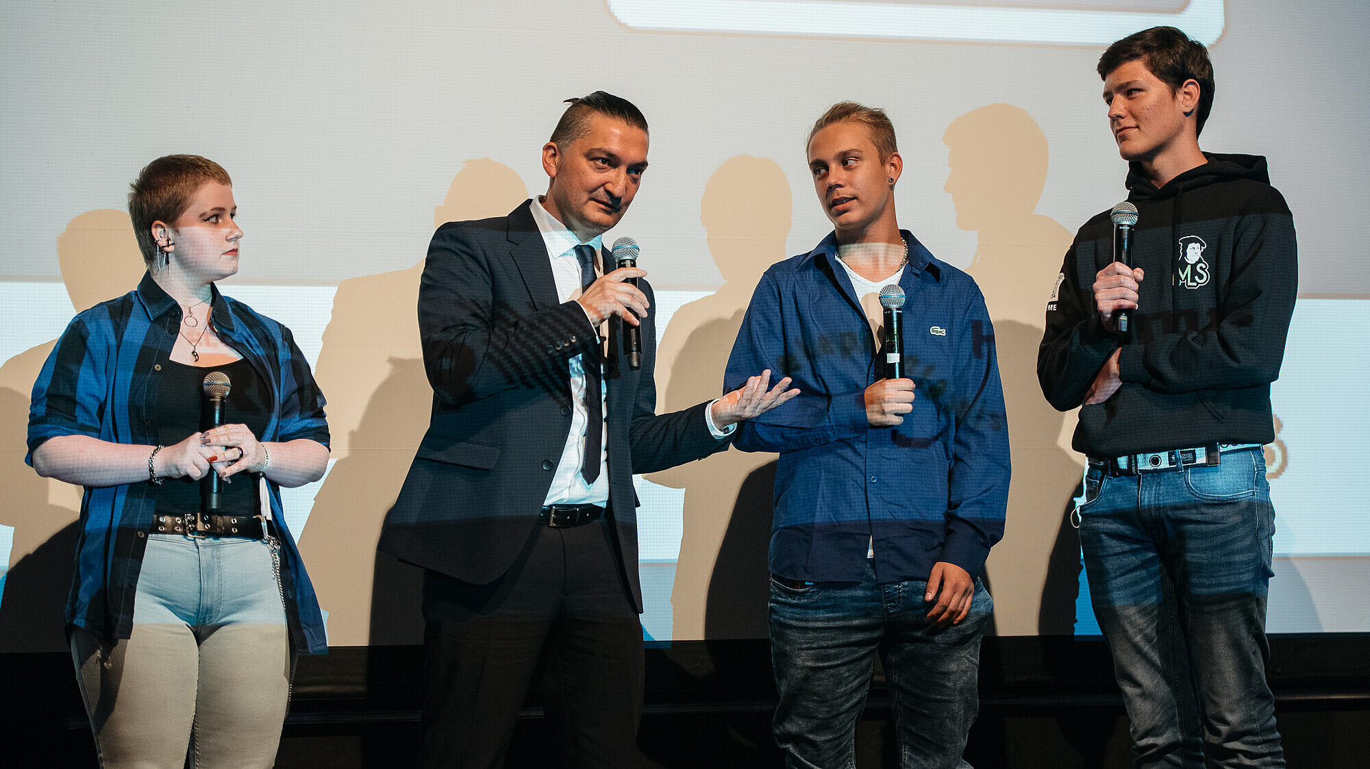 Mandy Schuster, Leon Bergmann und Julian Pauls mit ihrem Lehrer Selcuk Avci (2.v.l.) bei der Vorstellung der App. 