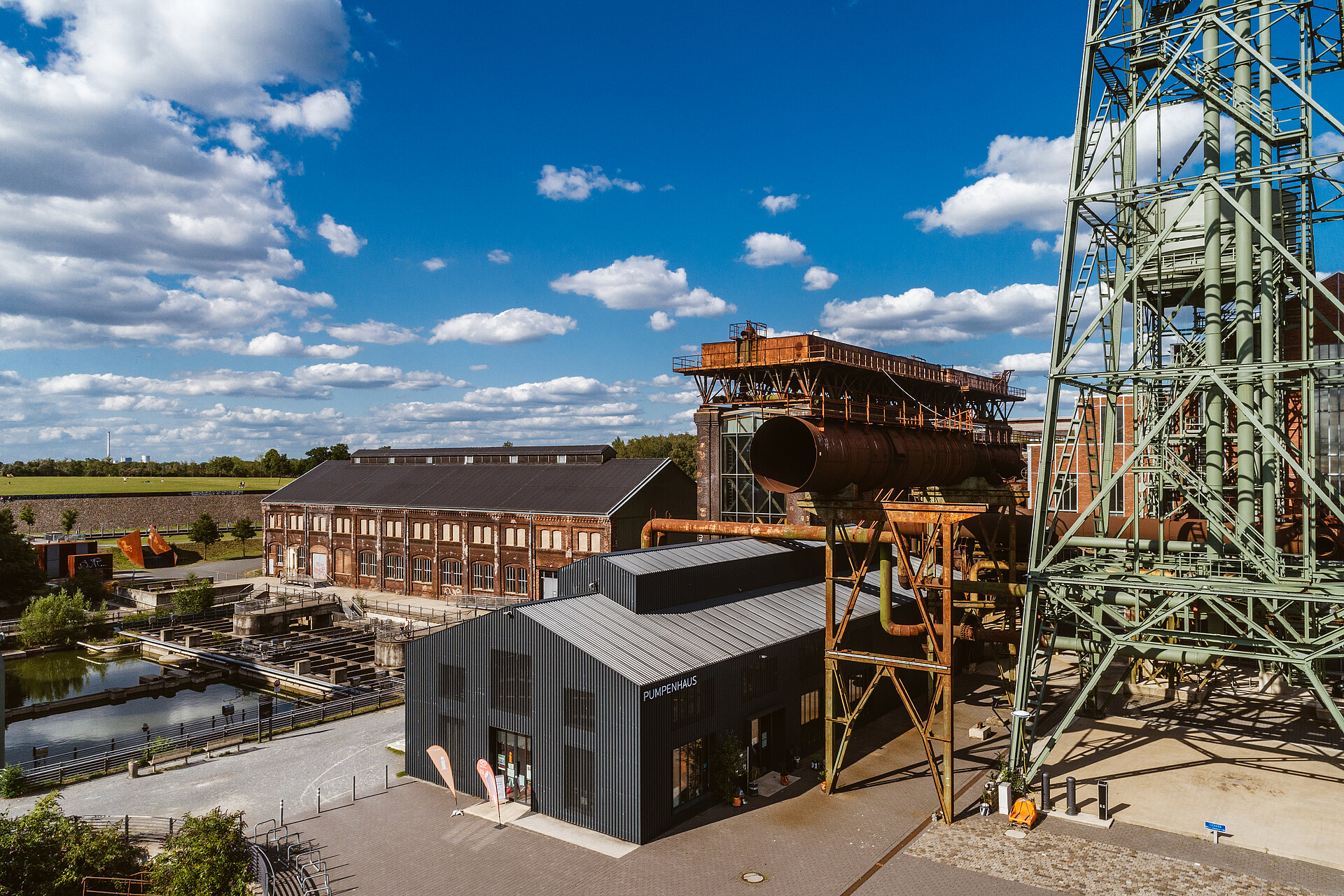Blick auf das Gelände der Jahrhunderthalle Bochum mit Turbinenhalle, Dampfgebläsehalle, Pumpenhaus und Wasserturm.