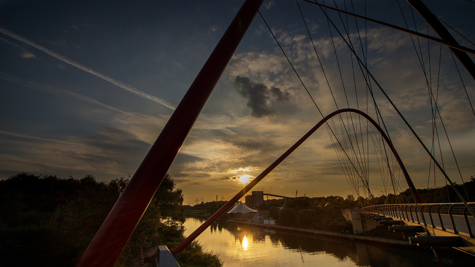 Die rote Doppelbogenbrücke über den Rhein-Herne-Kanal ist eines der Wahrzeichen des Nordsternparks Gelsenkirchen.