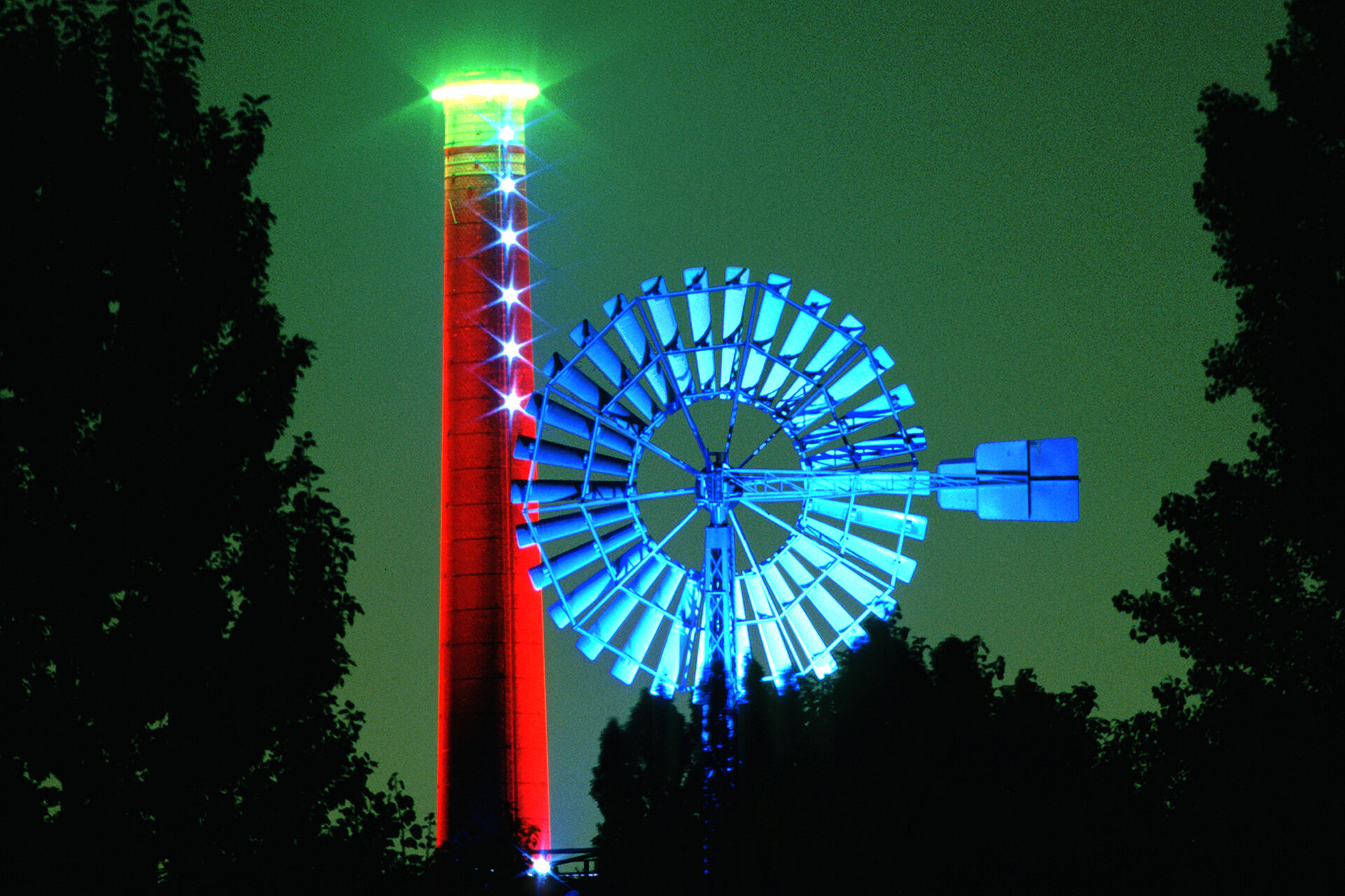 Windrat und Schlot im Landschaftspark Duisburg-Nord: Der britische Künstler Jonathan Park erschuf die Lichtinstallation im Jahre 1996 im Rahmen der Internationalen Bauaustellung (IBA) Emscher Park.