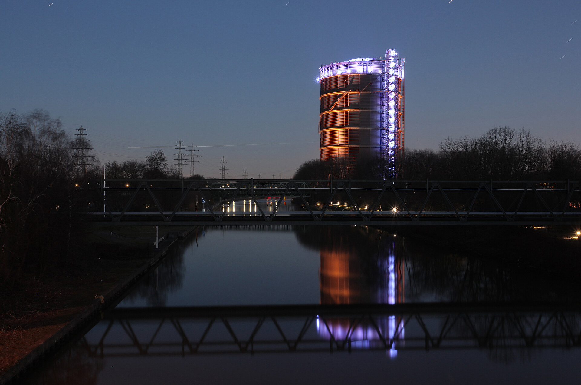 Gasometer Oberhausen nachts am Rhein-Herne-Kanal.